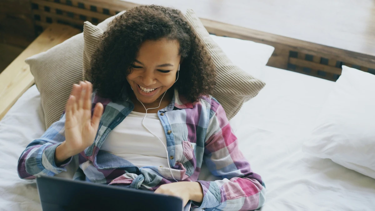 Young adult talking to a laptop during a virtual mental health counseling session
