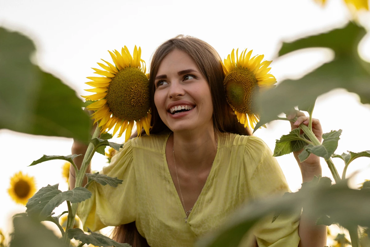 Happy young woman holding fresh flowers symbolizing joy, growth, and emotional healing in counseling